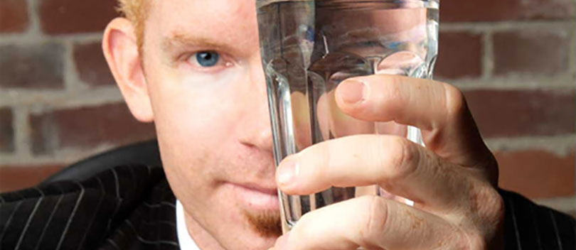 Ed Quilty looking through a water glass.