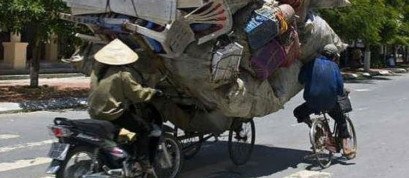 Two people on overpacked bikes.