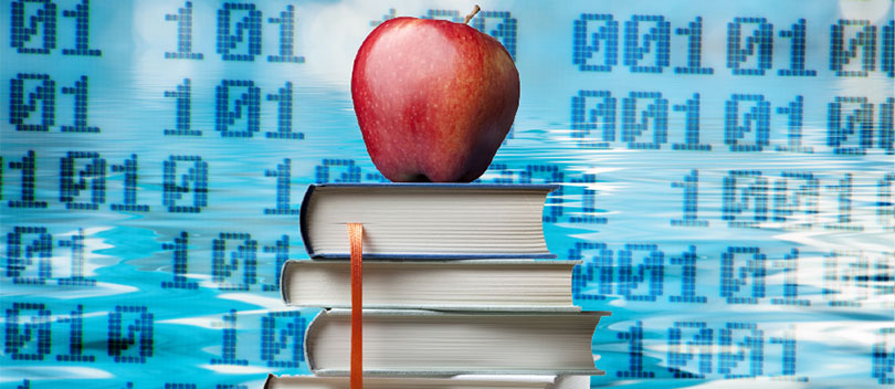 Apple resting on a stack of books.