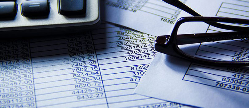 Glasses and calculator on sheets of data.