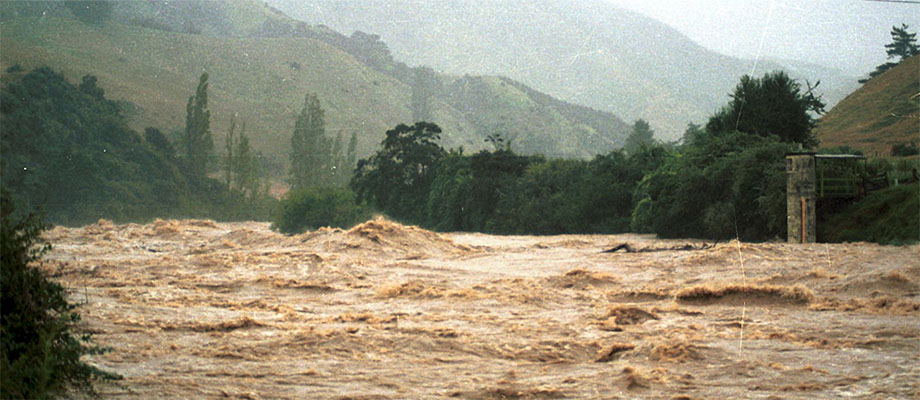 Turbulent River Surrounded by Hills and Trees.
